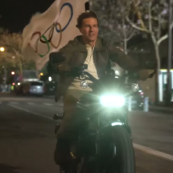 Tom Cruise on the motorcycle with the Olympic flag